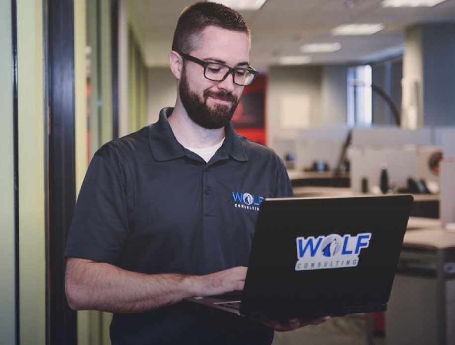 A Wolf Consulting engineer working on a laptop at the Pittsburgh managed IT office